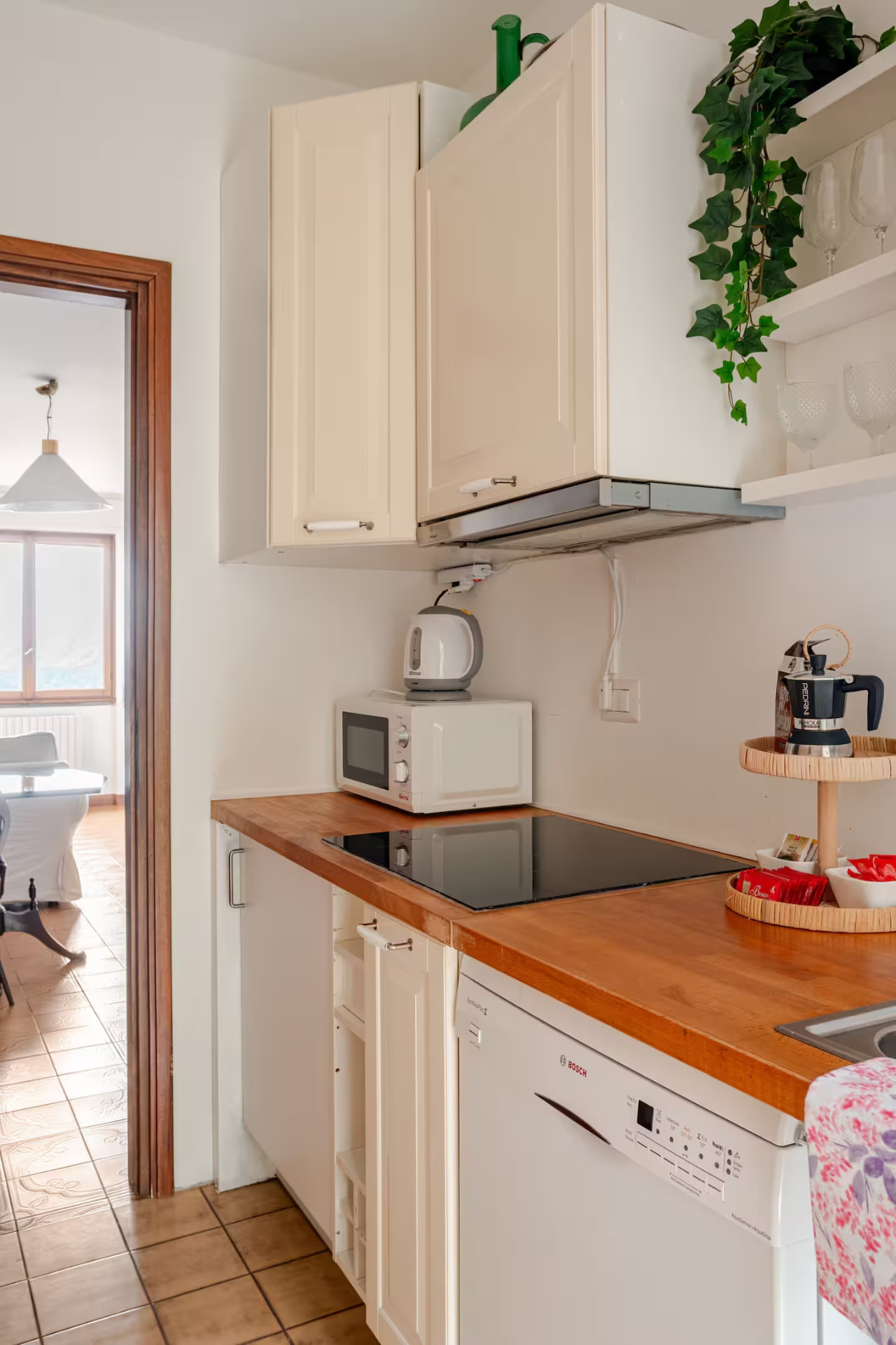 Kitchen with wooden worktop, induction hob, dishwasher and moka pot
